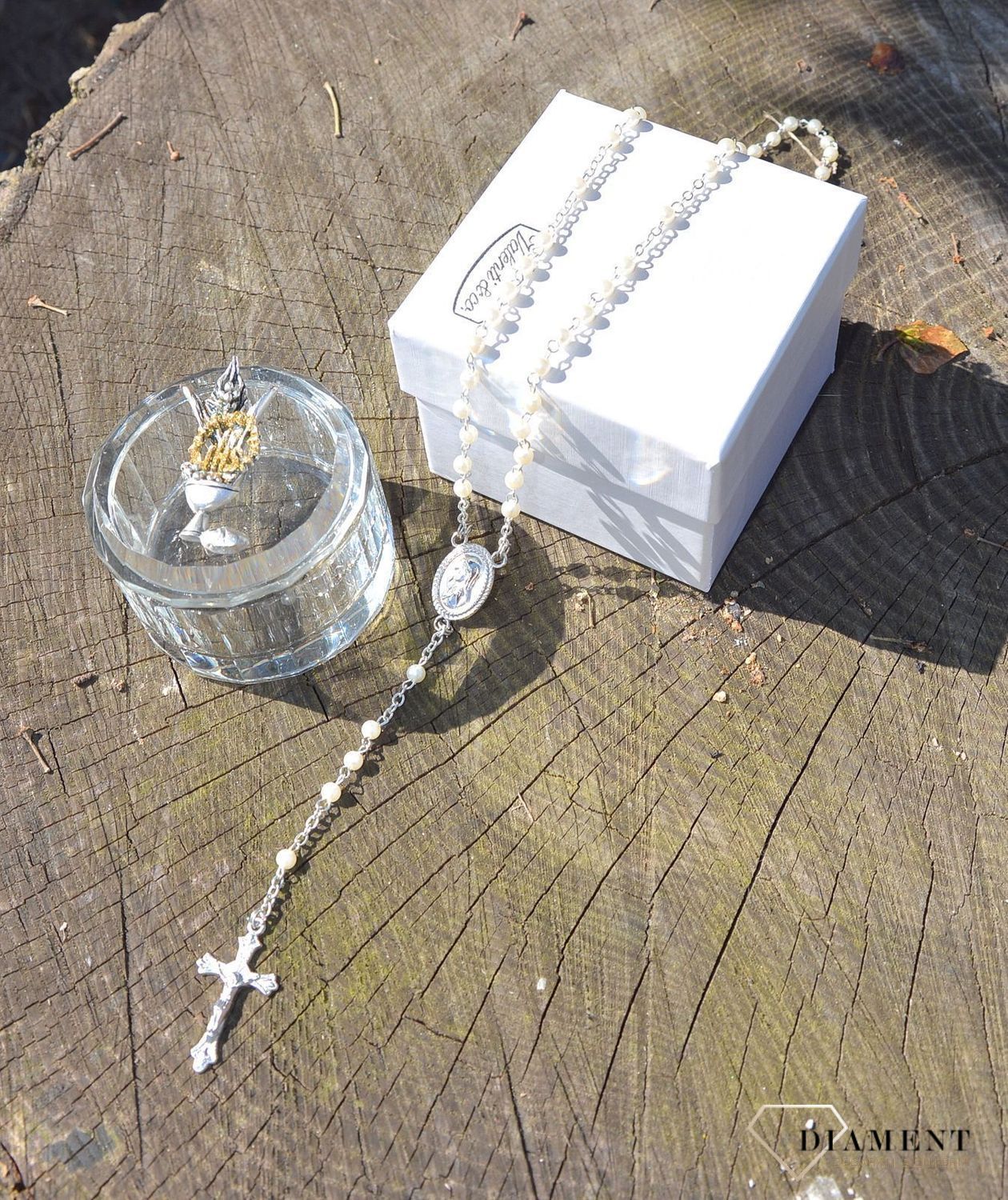 Różaniec komunijny z koralików w kolorze perłowym. Umieszczony w pięknie zdobionym szklanym opakowaniu. Na pokrywce starannie wykonany symbol komunijny - Hostia (1).JPG